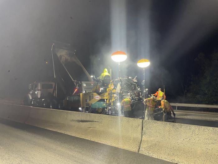 Construction vehicle and workers paving along Route 8