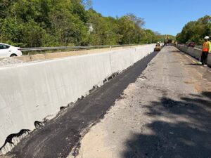 Paving next to the new concrete barrier in the median