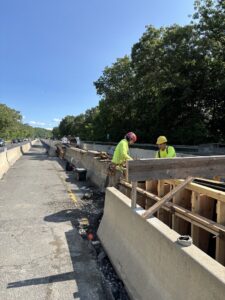 Workers install form for new concrete barrier