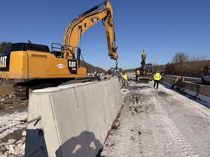 Workers install of pre-cast concrete median barrier between Exit 14 & 15
