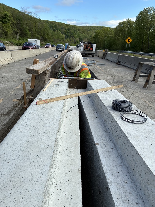 Worker installing permanent concrete barrier
